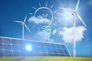 Das Bild zeigt ein Szenario für erneuerbare Energien mit Sonnenkollektoren und Windturbinen unter einem blauen Himmel mit ein paar Wolken. Die Sonnenstrahlen werden von den Solarzellen reflektiert, was die Energiegewinnung unterstreicht. Die weiße Zeichnung einer Glühbirne mit Strahlen im Himmel symbolisiert die Idee von Innovation und Nachhaltigkeit.