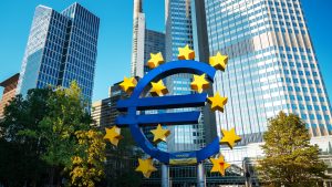 Die Euro-Skulptur mit gelben Sternen vor modernen Hochhäusern im Bankenviertel von Frankfurt am Main – Symbol der Europäischen Zentralbank und der Eurozone.