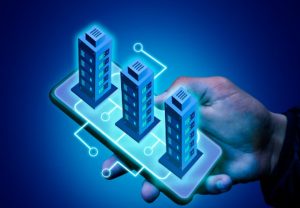 Eine Hand hält ein Smartphone, auf dem digital drei vernetzte Hochhäuser dargestellt sind – symbolische Darstellung für die Digitalisierung des Immobilienmarktes durch Immobilien-Token in Deutschland.