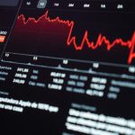 Ein digitaler Bildschirm zeigt rote Börsenkurse und fallende Aktiencharts – visuelle Darstellung von Marktschwankungen und Risiken im Zusammenhang mit Investitionen an den Finanzmärkten.