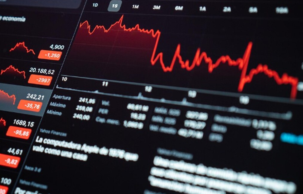 Ein digitaler Bildschirm zeigt rote Börsenkurse und fallende Aktiencharts – visuelle Darstellung von Marktschwankungen und Risiken im Zusammenhang mit Investitionen an den Finanzmärkten.