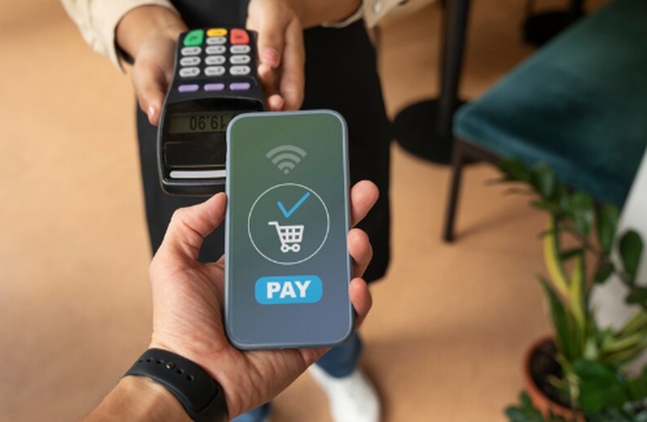 Eine Person hält ein Smartphone mit einer digitalen Bezahlbestätigung über ein kontaktloses Terminal – modernes Beispiel dafür, wie Karten virtuell für schnelle und sichere Zahlungen verwendet werden.