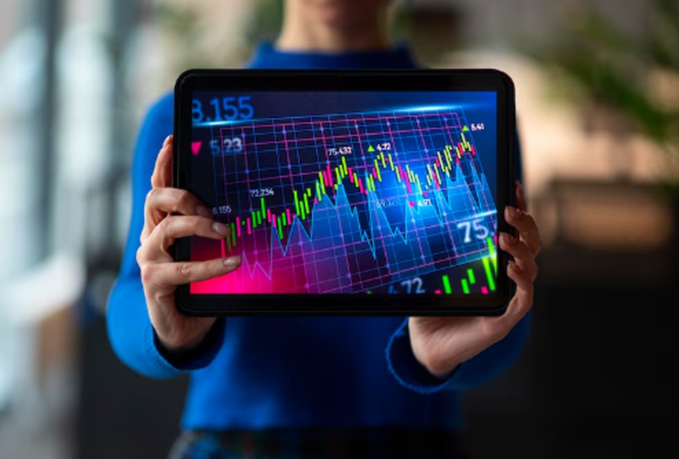 Eine Person hält ein Tablet mit einer farbigen Finanzgrafik, die Kursbewegungen und Zahlen darstellt – symbolische Darstellung der Analyse und Überwachung des deutschen Aktienmarkts in Echtzeit.